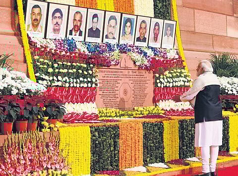 Prime Minister Narendra Modi pays floral tribute to the martyrs who lost their lives in the 2001 Parliament attack, during a ceremony at the Samvidhan Sadan in New Delhi on Wednesday; (Left) Oppositio