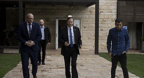 Israel's President Isaac Herzog, center, walks with his staff after an interview at his official residence in Jerusalem. (Photo | AP)