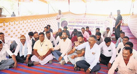 Members of the Karnataka Liquor Lovers Association sit in protest outside Suvarna Vidhana Soudha in Belagavi on Thursday | Express