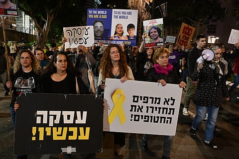 Friends and relatives of Israeli hostages held in Gaza since the October 7 attack lift placards during a demonstration in Tel Aviv on December 16, 2023. (Photo | AFP)