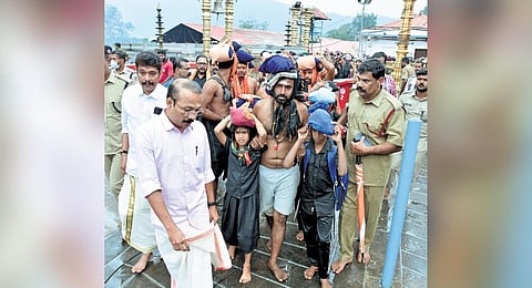 TDB president P S Prasanth takes child pilgrims through the special gate for darshan atSabarimala temple on Sunday | Express