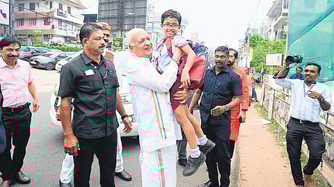 Arif Mohammed Khan lifting a boy when he arrived near Mananchira in Kozhikode.