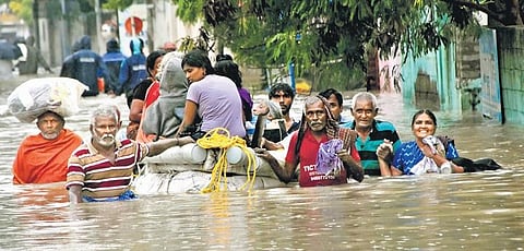 Residents moving to safer locations with the help of a makeshift boat at Muthammal Colony Road in Thoothukudi on Monday | V KARTHIK ALAGU