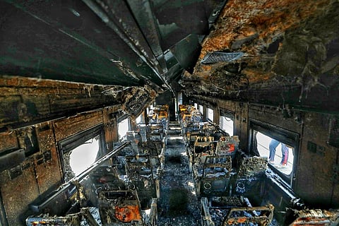 A general view of a burned out railway coach after it WAS allegedly set on fire by opposition activists, in Dhaka on December 19, 2023. (Photo | AFP)