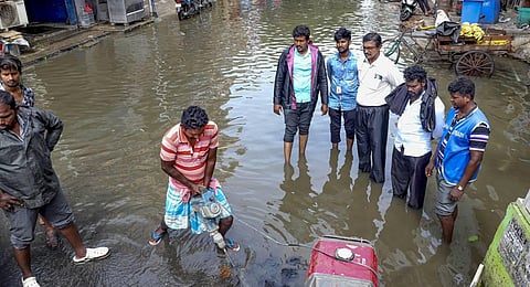 Locals use a pump set to remove water from a waterlogged street after heavy rain, in Chennai. (Photo | PTI)