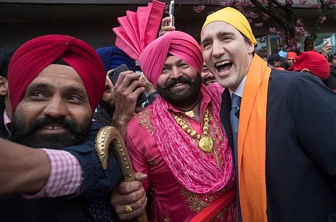 Canadian PM Justin Trudeau, right, poses for a photograph after marching in the Vaisakhi parade in Vancouver on April 13. Canada is the No 1 destination for Punjabi immigrants.(File Photo | AP)