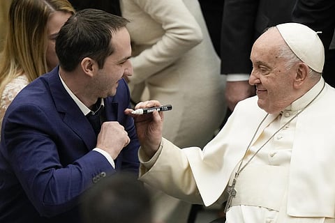 Pope Francis autographs the suit of a newly wed groom during his weekly general audience in the Pope Paul VI hall at the Vatican, Wednesday, Dec. 20, 2023. (Photo | AP)