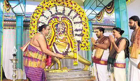 Priests performing deepa aradhanai to Lord Shani idol bearing a golden armour and perched on a golden crow on Sani Peyarchi, on Wednesday | antony fernando