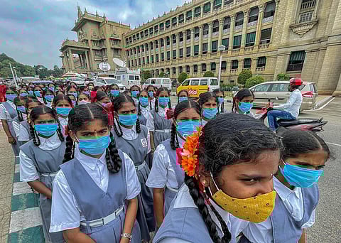 School students wearing masks in precaution against COVID visit the Vidhana Soudha, in Bengaluru. (Photo | PTI)