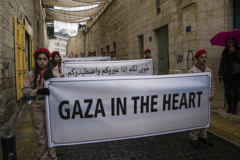 Palestinian scouts hold signs in solidarity with Palestinians near the Church of the Nativity, traditionally believed to be the birthplace of Jesus, in the West Bank city of Bethlehem | AP