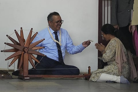 World Health Organization Director General Tedros Adhanom Ghebreyesus seen trying his hands on a spinning wheel during his visit to Gandhi Ashram in Ahmedabad. (File Photo | AP)