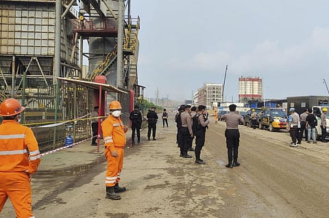 Police officers and workers stand near the site where a furnace explosion occurred at PT Indonesia Tsingshan Stainless Steel smelting plant in Morowali, Central Sulawesi, Indonesia. (Photo | AP)