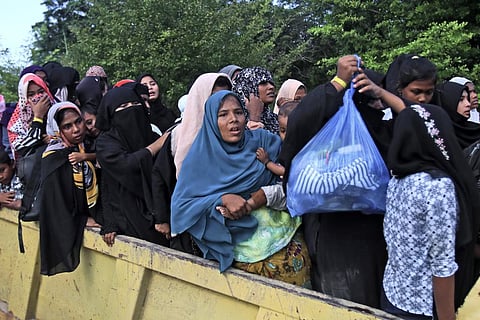 Ethnic Rohingya women and children board a truck as they are being relocated from their temporary shelter at the basement of a community hall following a protest rejecting Rohingya refugees | AP