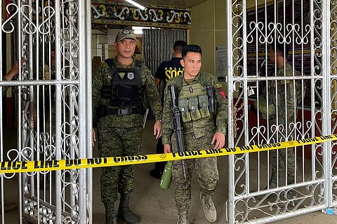 Military personnel stand guard at the entrance of a gymnasium while police investigators look for evidence after a bomb attack at Mindanao State University in Marawi on December 3, 2023. (Photo | AFP)
