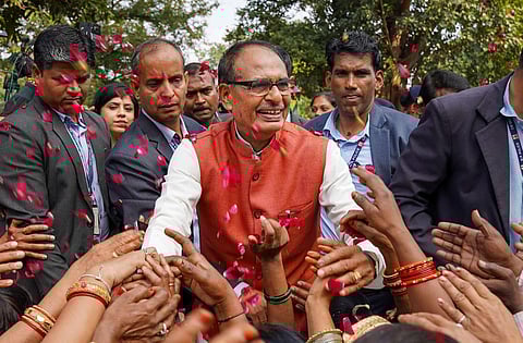 Madhya Pradesh Chief Minister Shivraj Singh Chouhan with BJP workers and supporters celebrates the party's lead during counting of votes for MP Assembly elections, in Bhopal, Sunday. (PTI Photo)
