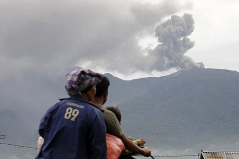 Motorists ride past by as Mount Marapi spews  volcanic materials during its eruption in Agam, West Sumatara, Monday, Dec 4, 2023. (Photo / AP)