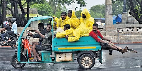 GCC workers having a light moment while travelling in their vehicle near war memorial as cyclone Michaung approaches Chennai coast | P RarAvikumar