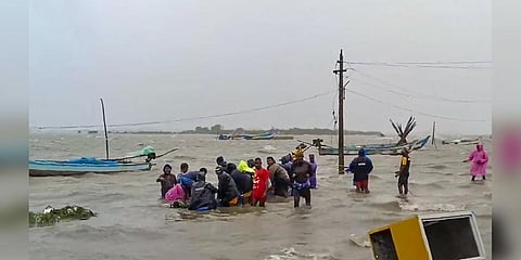 Residents shift to a safer place from a flooded area after heavy rain owing to Cyclone Michaung, in Tiruvallur district. (Photo | PTI)
