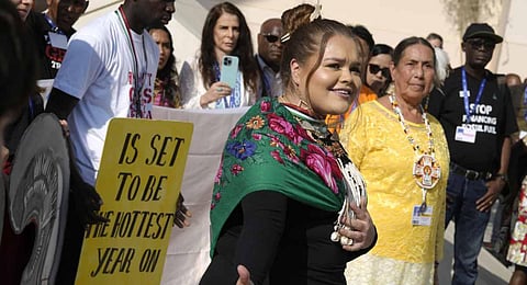 Danielle Frank, center, participates in a demonstration with her grandmother, Kathryn Diane Horinek at the COP28 U.N. Climate Summit. (Photo | AP)