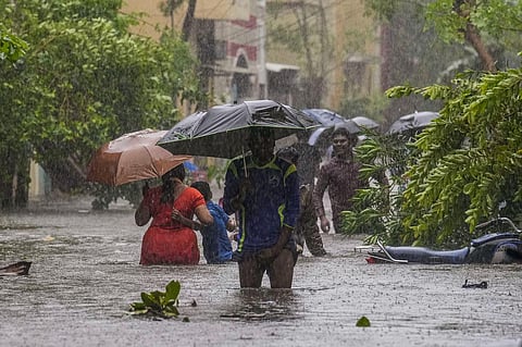 People wade through a flooded road after heavy rainfall owing to Cyclone Michaung, in Chennai, Tuesday, Dec. 5, 2023. (Photo | PTI)