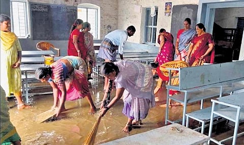 Workers clearing rain water from a classroom in a school at Thimmampalayam  | Express