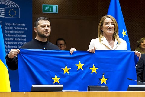 Ukraine's President Volodymyr Zelenskyy (L) and European Parliament President Roberta Metsola hold up a European Union flag at the European Parliment in Brussels, Feb. 9, 2023. (Photo | AP)