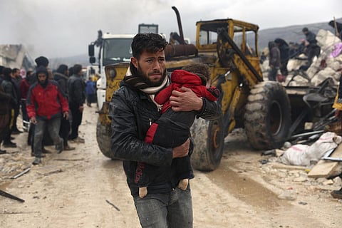 A man carries the body of an earthquake victim in the Besnia village near the Turkish border, Idlib province, Syria. (Photo | AP)