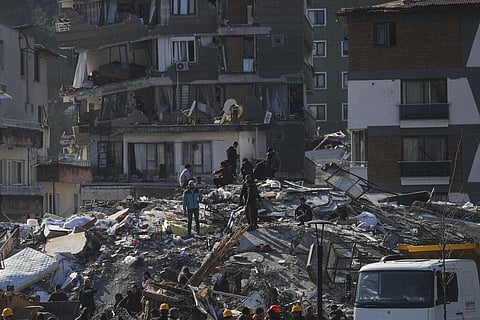 Men walk among the debris of collapsed buildings in Hatay, southern Turkey, Thursday, Feb. 9, 2023. (Photo | AP)
