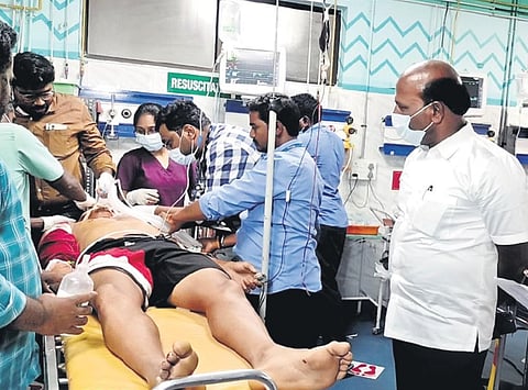 Health Minister Ma Subramaniam with an accident victim at the Rajiv Gandhi Government General Hospital | special arrangement