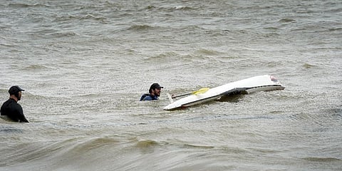 Two men are seen kayaking amid a tropical storm in French Bay, located in the Auckland Region of New Zealand's North Island on February 13, 2023. (Photo | AFP)