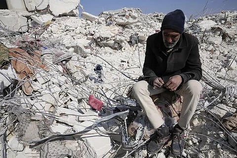 A man sits in the rubble of a destroyed building in Atareb, Syria, Sunday, Feb. 12, 2023. (Photo | AP)