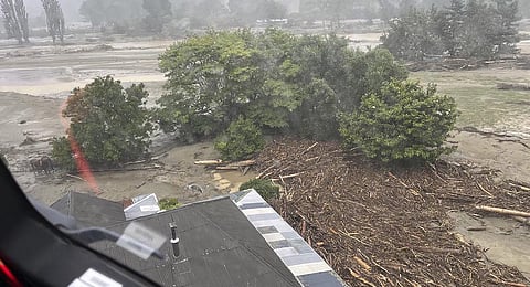 In this image released by the New Zealand Defense Force on Wednesday, Feb. 15, 2023, debris and logs pile up against a building after flooding in the Esk Valley. (Photo | AP)