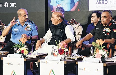 Defence Minister Rajnath Singh in conversation with Air Chief Marshal VR Chaudhari at Aero India on Tuesday. Chief of Army Staff General Manoj Pande looks on   | Shashidhar Byrappa