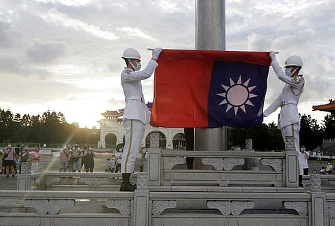 Two soldiers fold the national flag during the daily flag ceremony in Liberty Square of Chiang Kai-shek Memorial Hall in Taipei, Taiwan, Saturday, July 30, 2022. (Photo | AP)