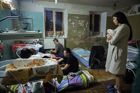 A woman holds her newborn child in a maternity hospital’s basement used as a bomb shelter during an air raid alert in Kyiv, Ukraine, Wednesday, March 2, 2022. (Photo | AP)