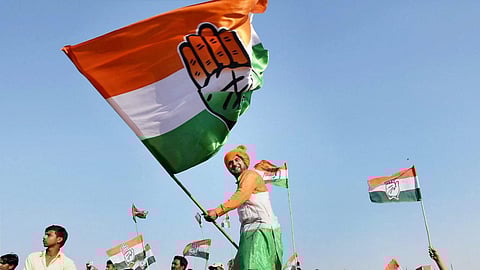 A file photo of a Congress supporter waving the party flag during a rally. 