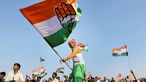 A file photo of a Congress supporter waving the party flag during a rally. 