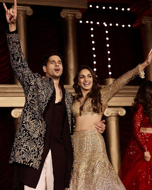 Manish Malhotra described the bride's look: 'Kiara embraces extravagant glamour in our artistic ombre lehenga, personalised to make more than just a statement, featuring meticulous handwork that took 4000 hours to craft. A striking gold to silver transition, 98000 sparkling swarovski crystals are paired with our haute couture stole with marabou feather detailing. The custom look was paired with a captivating neckpiece in a careful curation of natural diamonds and a colossally enchanting ruby pendant from the Manish Malhotra High Jewellery collection.' (Photo | Kiara Advani Instagram)