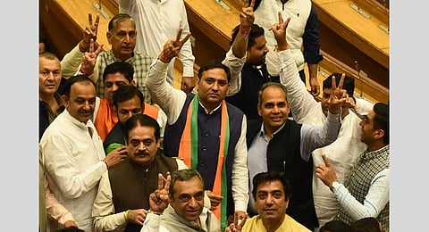 Councillor Pawan Sehrawat, who joined BJP leaving AAP, flashes the victory sign during the election of members of the MCD Standing Committee, at the Civic Centre in New Delhi, Friday, Feb. 24.
