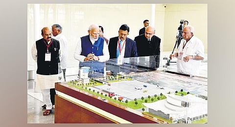 Prime Minister Narendra Modi views a scale model of the airport, as CM Basavaraj Bommai and former CM BS Yediyurappa look on, in Shivamogga on Monday | Express