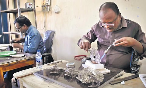 Artisans create silver filigree  articles for the G20 summit in Karimnagar on Saturday