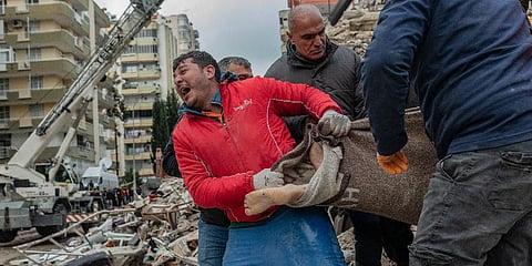 A rescuer reacts as he carries a body found in the rubble in Adana on February 6, 2023, after a 7.8-magnitude earthquake struck the country's south-east. (Photo | AFP)