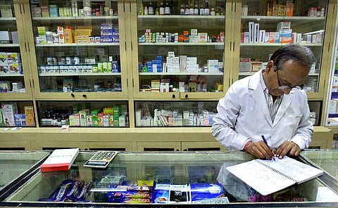 An unidentified Indian pharmacist checks his stock of medicines at a pharmacy in New Delhi. 