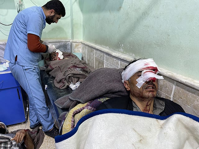 An injured child and two men receive treatment at the hospital following an earthquake, in the rebel-held northern countryside of Syria's Idlib province on the border with Turkey, early on February 6, 2023. (Photo | AFP)