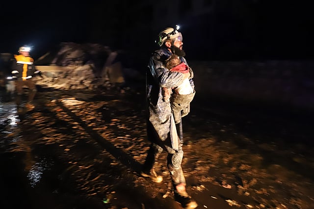 A member of the Syrian civil defence, known as the White Helmets, carries a child rescued from the rubble following an earthquake in the town of Zardana in the countryside of the northwestern Syrian Idlib province, early on February 6, 2023.   (Photo | AFP)