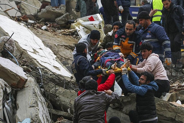 People and emergency teams rescue a person on a stretcher from a collapsed building in Adana, Turkey, Monday, Feb. 6, 2023. (Photo | AP)