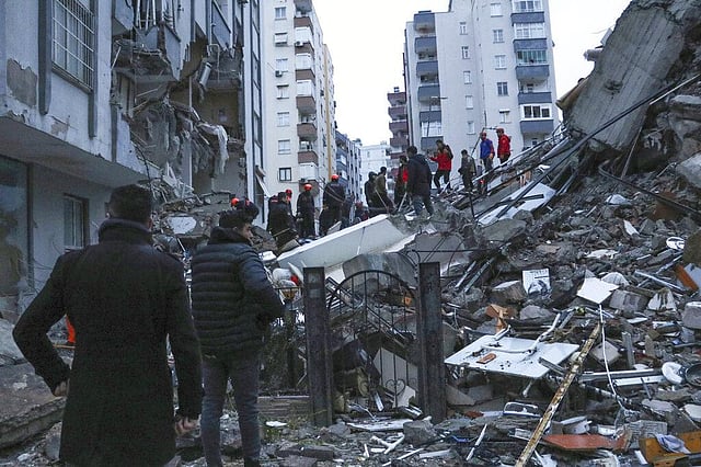 People and rescue teams try to reach trapped residents inside collapsed buildings in Adana, Turkey, Monday, Feb. 6, 2023. A powerful quake has knocked down multiple buildings in southeast Turkey and Syria and many casualties are feared. (Photo | AP)