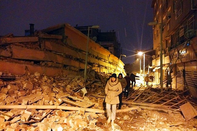 People walk next to buildings destroyed by an earthquake in Malatya, Turkey, Monday, Feb. 6, 2023. A powerful quake has knocked down multiple buildings in southeast Turkey and Syria and many casualties are feared. (Photo | AP)