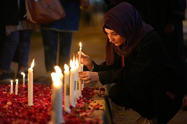 A woman lights candles during a vigil for the victims of earthquake in Syria and Turkey, in Islamabad, Pakistan, Monday, Feb. 6, 2023.  (Photo | AP)