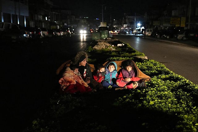 A family who fled the war in Syria and live in Beirut, sit outside their home following an earthquake that hit neighboring Turkey early Monday, Feb. 6, 2023, in south of Beirut, Lebanon. Many residents in Lebanon left their homes and took to the streets or drove in their cars away from buildings. (Photo | AP)